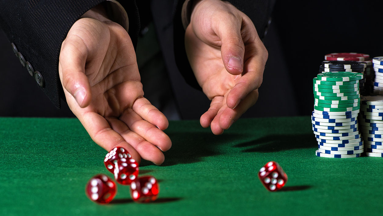 Male hand rolling five dice on green felt | IT Exchange